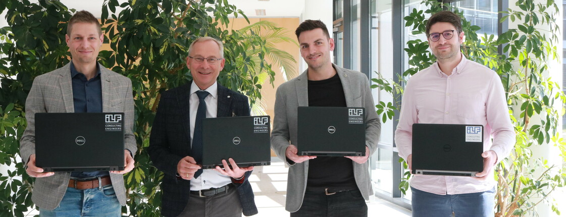 Gruppenfoto von vier Männern mit Laptops in den Händen.