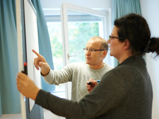 Bildungsreferent zeigt auf ein Whiteboard