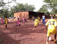 Kinder mit gelben und rosa Trickots spielen Fußball 