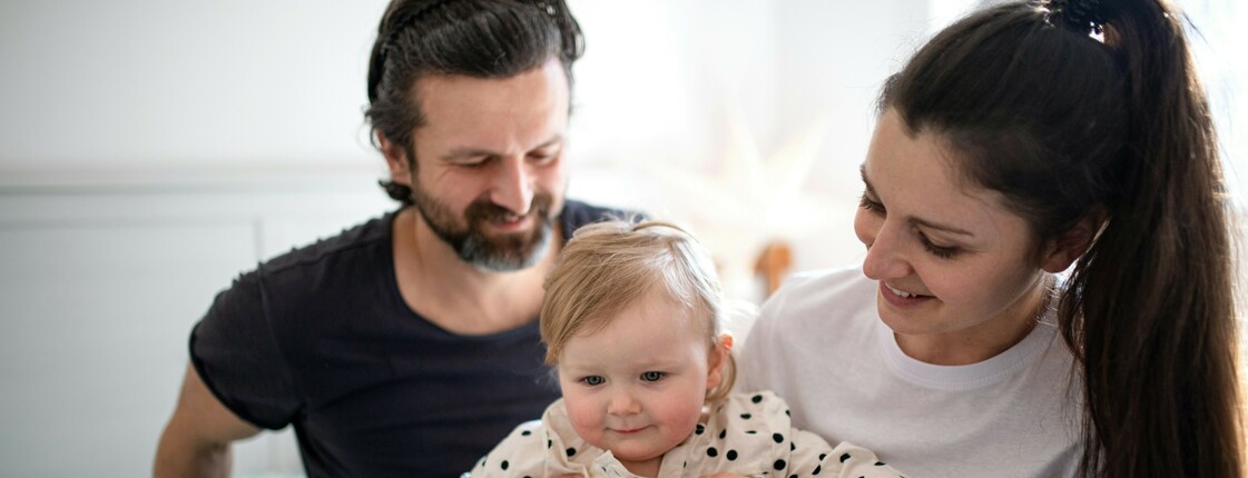 Portrait einer glücklichen Familie mit einer kleinen Tochter, die zuhause sind.