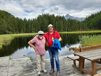 Zwei Männer stehen vor einem Bergsee zu einem Foto zusammen.