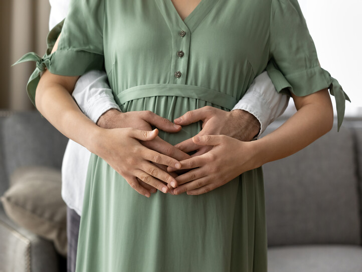 Close up cropped of pregnant woman with husband touching belly