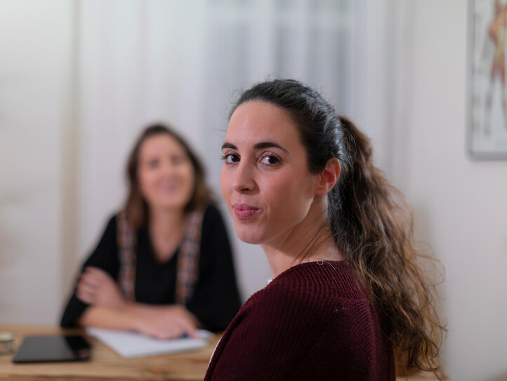 A female patient looks at camera during an interview with her therapist to resolve her health issues