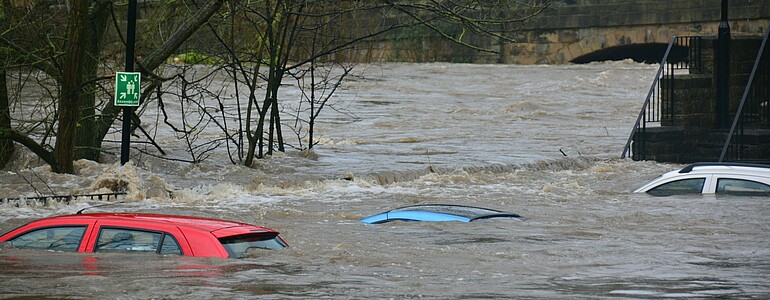 Drei parkende Autos sind bei einem Hochwasser überschwemmt worden.