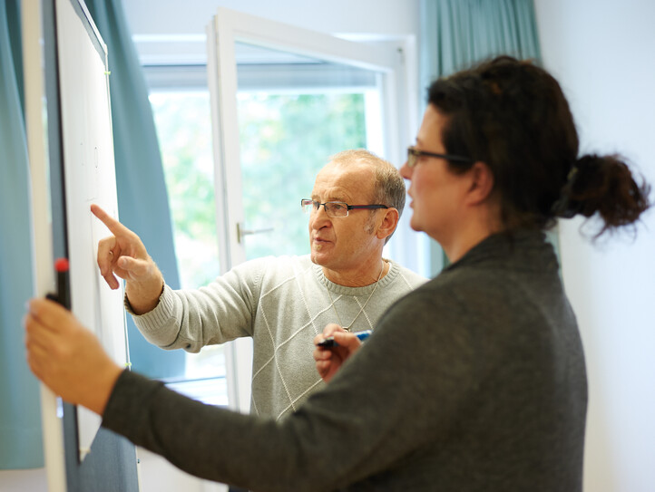 Bildungsreferent und Studentin am Whiteboard